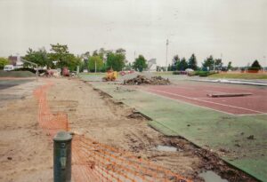 L’équipe ADN-SOL prépare un court de tennis en béton poreux pour sa rénovation, avec le chef de chantier supervisant les opérations pour garantir une surface optimale.