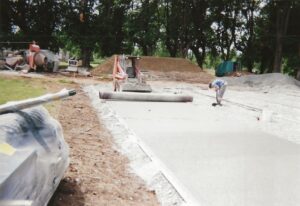 L’équipe ADN-SOL effectue des travaux de rénovation sur un court de tennis en béton poreux, avec des étapes minutieuses pour redonner une nouvelle vie à la surface sportive.