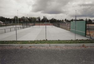 Un court de tennis en béton poreux fraîchement terminé par l’équipe ADN-SOL, en attente de la prochaine étape : l’application de la peinture pour marquer les lignes et finaliser la surface.