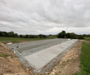 L’équipe ADN-SOL en pleine opération de coulage des dalles pour un court de tennis en béton poreux, garantissant une surface uniforme et durable.