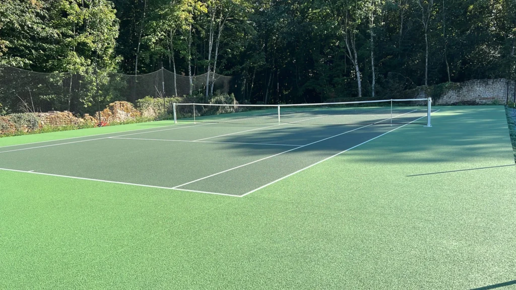 Court de tennis en béton poreux réalisé par ADN-SOL, spécialiste français de la construction et rénovation de terrains de tennis perméables.